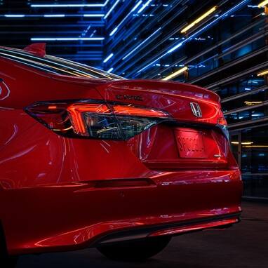 2027 Honda Civic Sedan Sport Touring Hybrid in Rallye Red rear three-quarter view showing taillight (Compact Sedan)